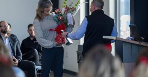 Deb Spencer being presented with flowers at the awards ceremony